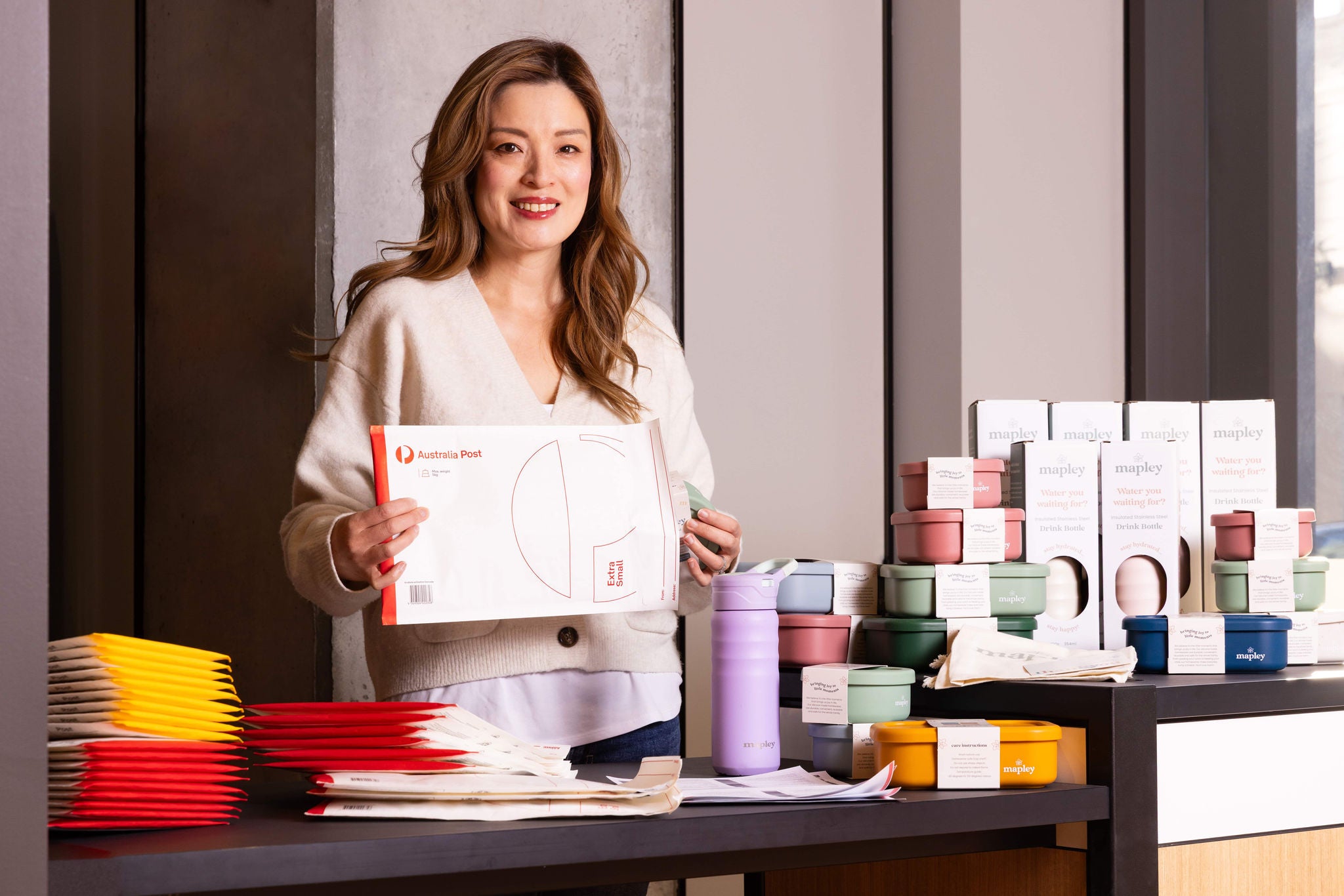 photo-woman-standing-holding-australia-post-satchel-mapley-products