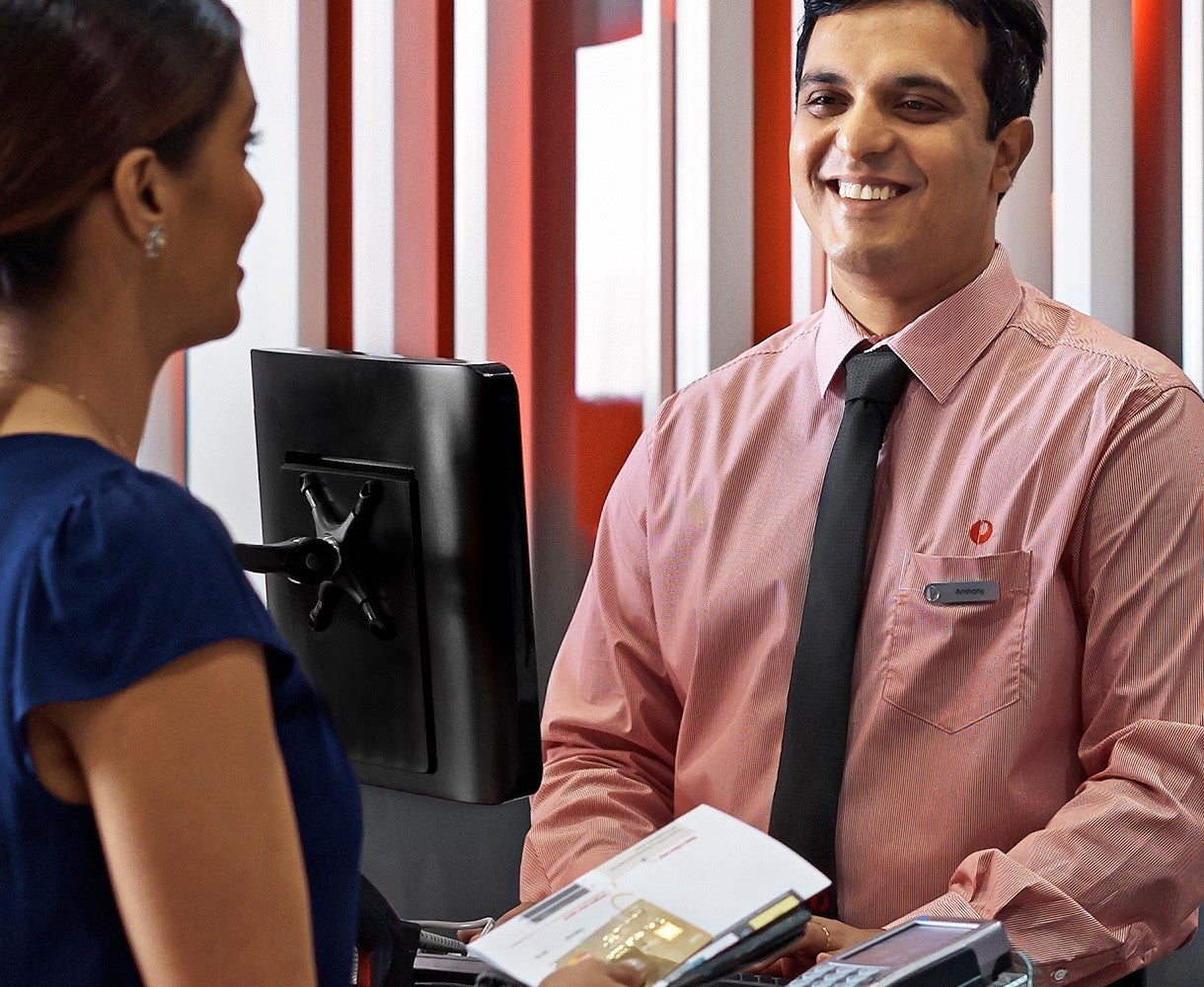 Post Billpay female customer paying bill at counter panoramic Landscape