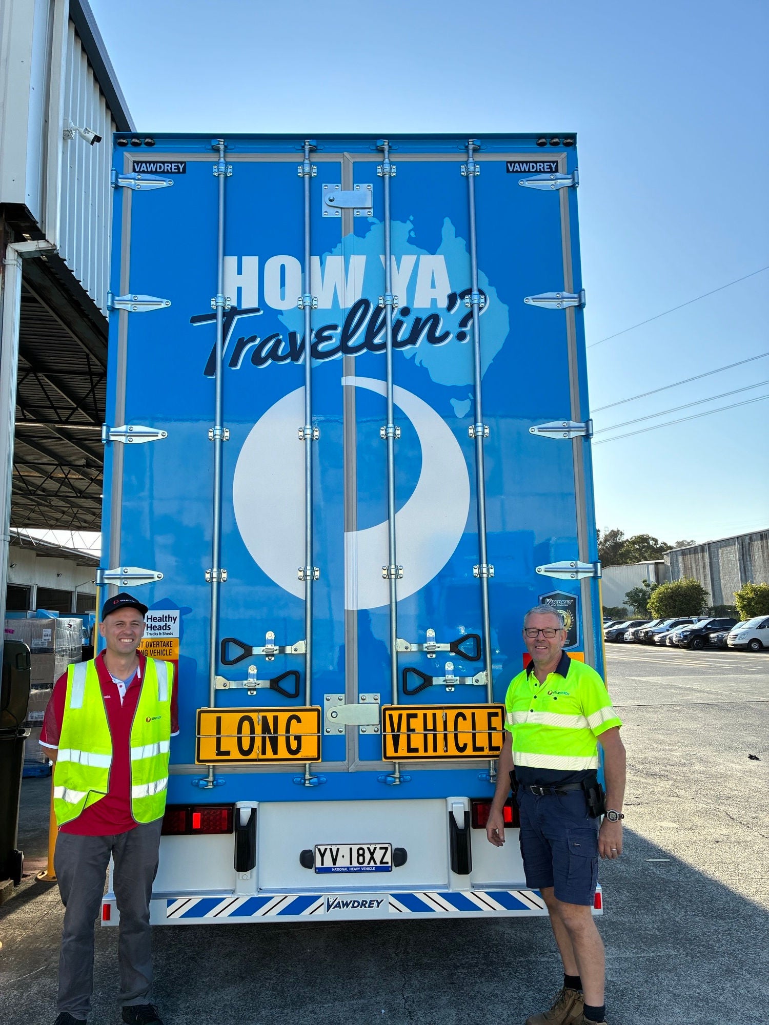 Two men standing at the rear of a strartrack truck