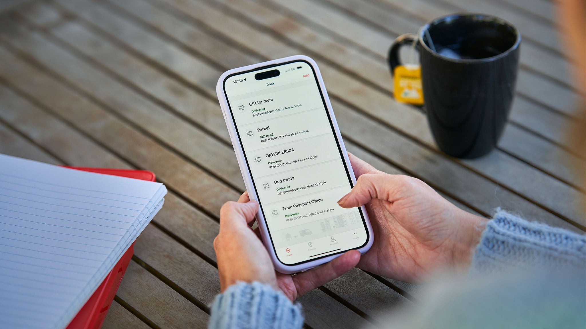 photo-close-up-of-hand-holding-phone-with-screen-showing-parcel-delivery-notifications