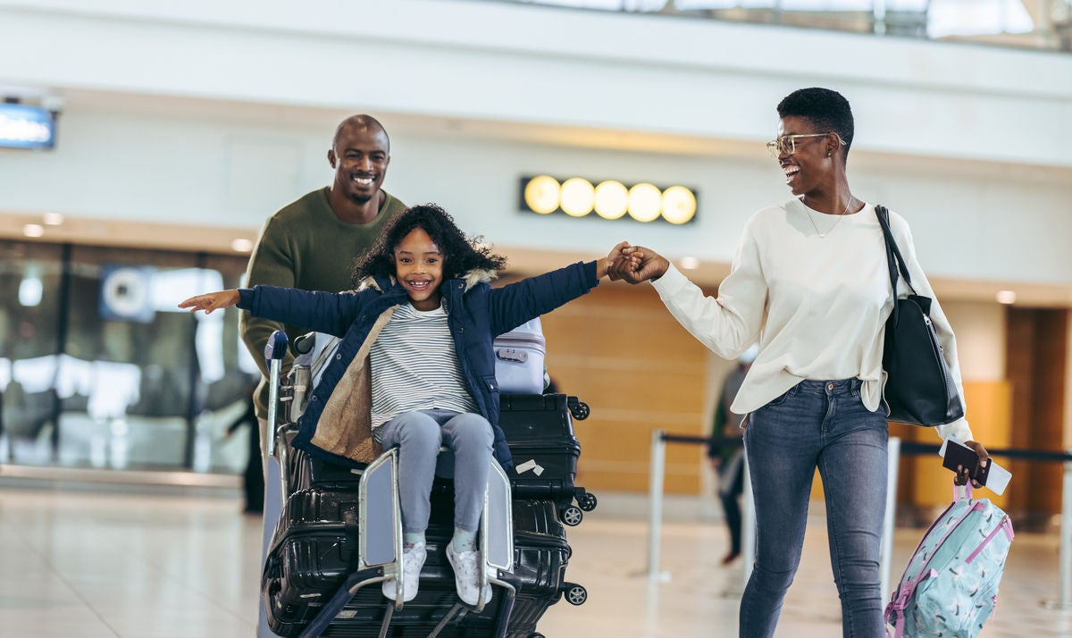 Family of three going on a holiday at airport. African family having fun at airport terminal.
