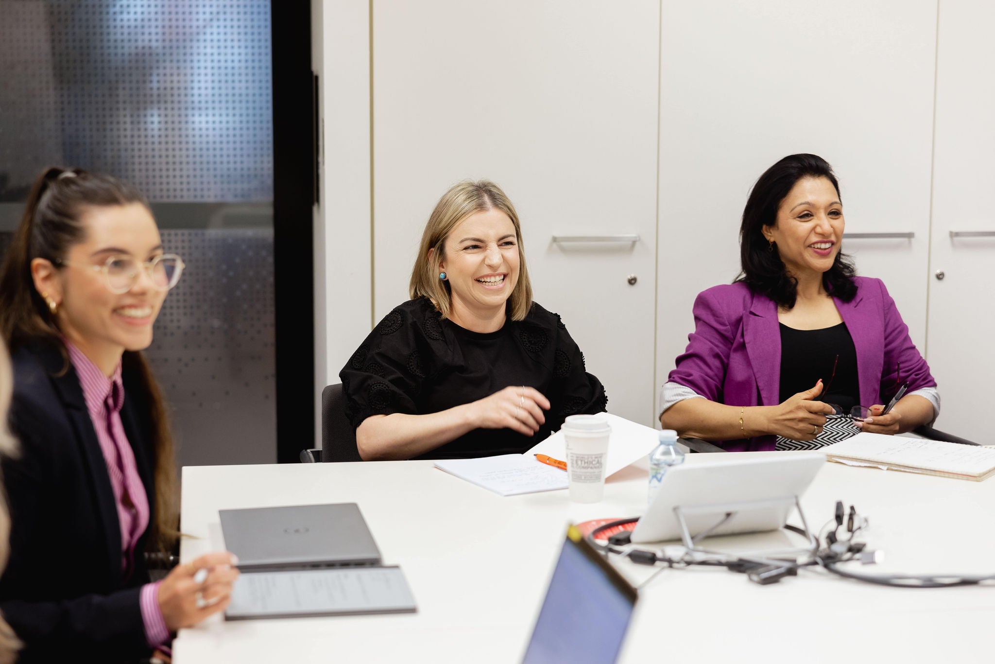 Photo of three people sitting in meeting room
