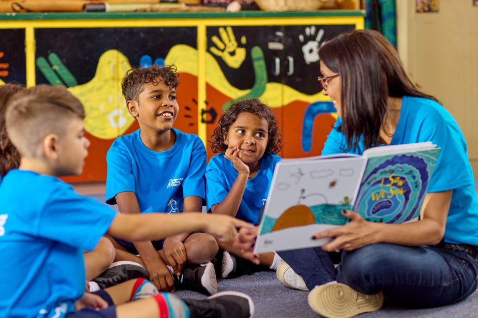 Woman reading a book to First Nations children