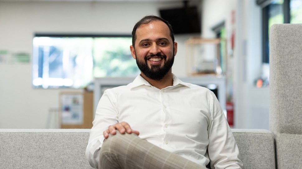 Female StarTrack driver in conversation with man in high-vis vest in a warehouse